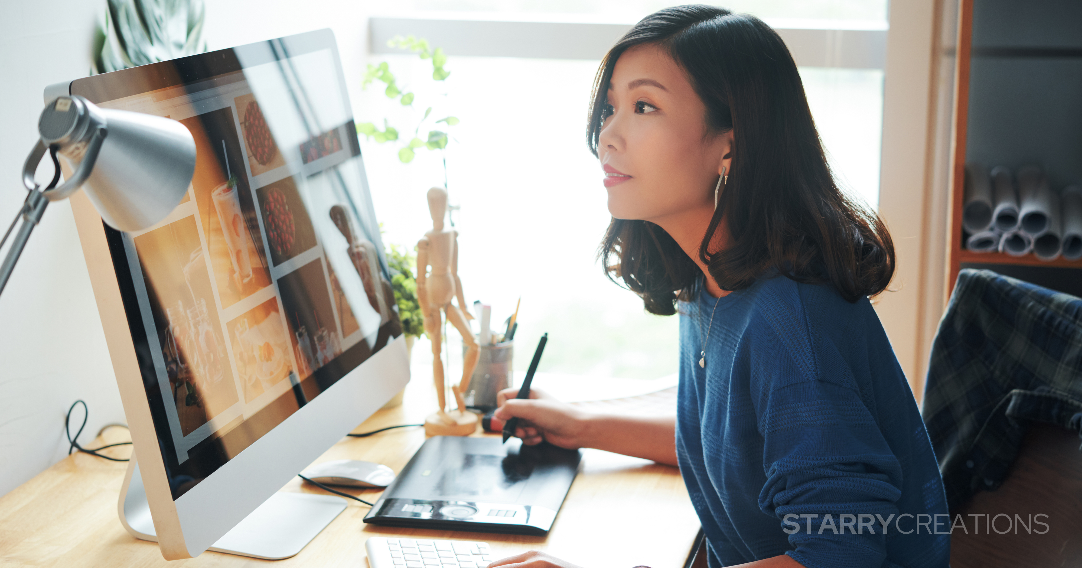 デスクトップPCとペンタブでデザイン作業を行う女性